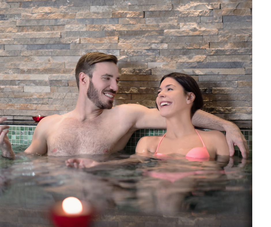 Photo of a young couple talking and laughing in a hot tub.