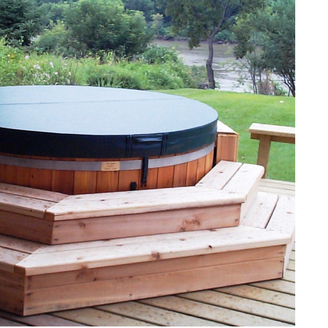 An outdoor hot tub built into a deck with a cover on.