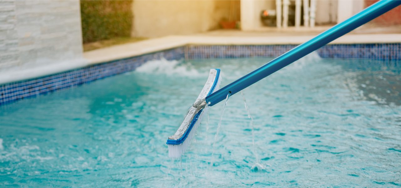 A pool brush entering the pool