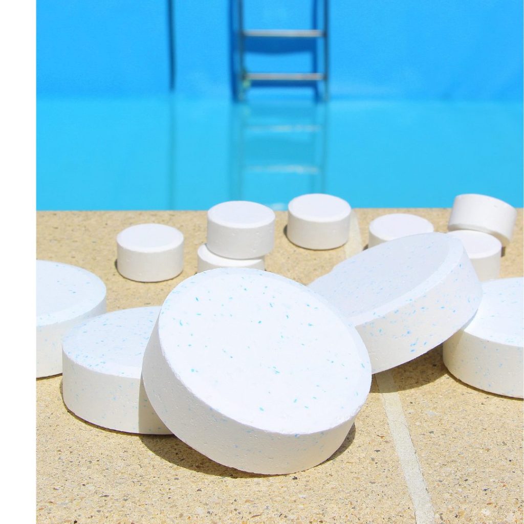 twelve white chlorine pellets scattered in front of a blue pool in the background.