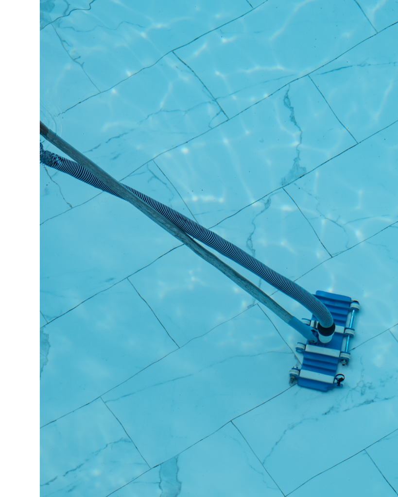 A blue pool brush reaches the bottom of the pool