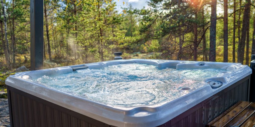 This step is to fill up the hot tub. This image displays a filled hot tub in the forest.